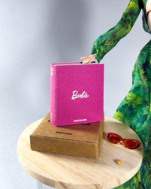 Libro miniatura escala 1:6 junto a muñeca de colección y caja